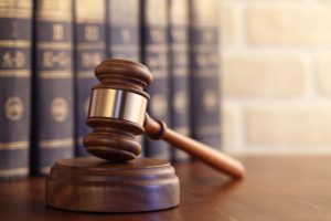 Gavel leaning against a row of law books