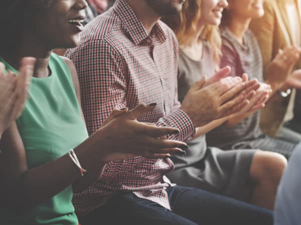 An audience of people clapping