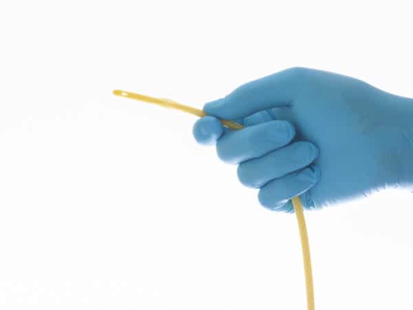 urethral catheter hold on blue glove hand on white background